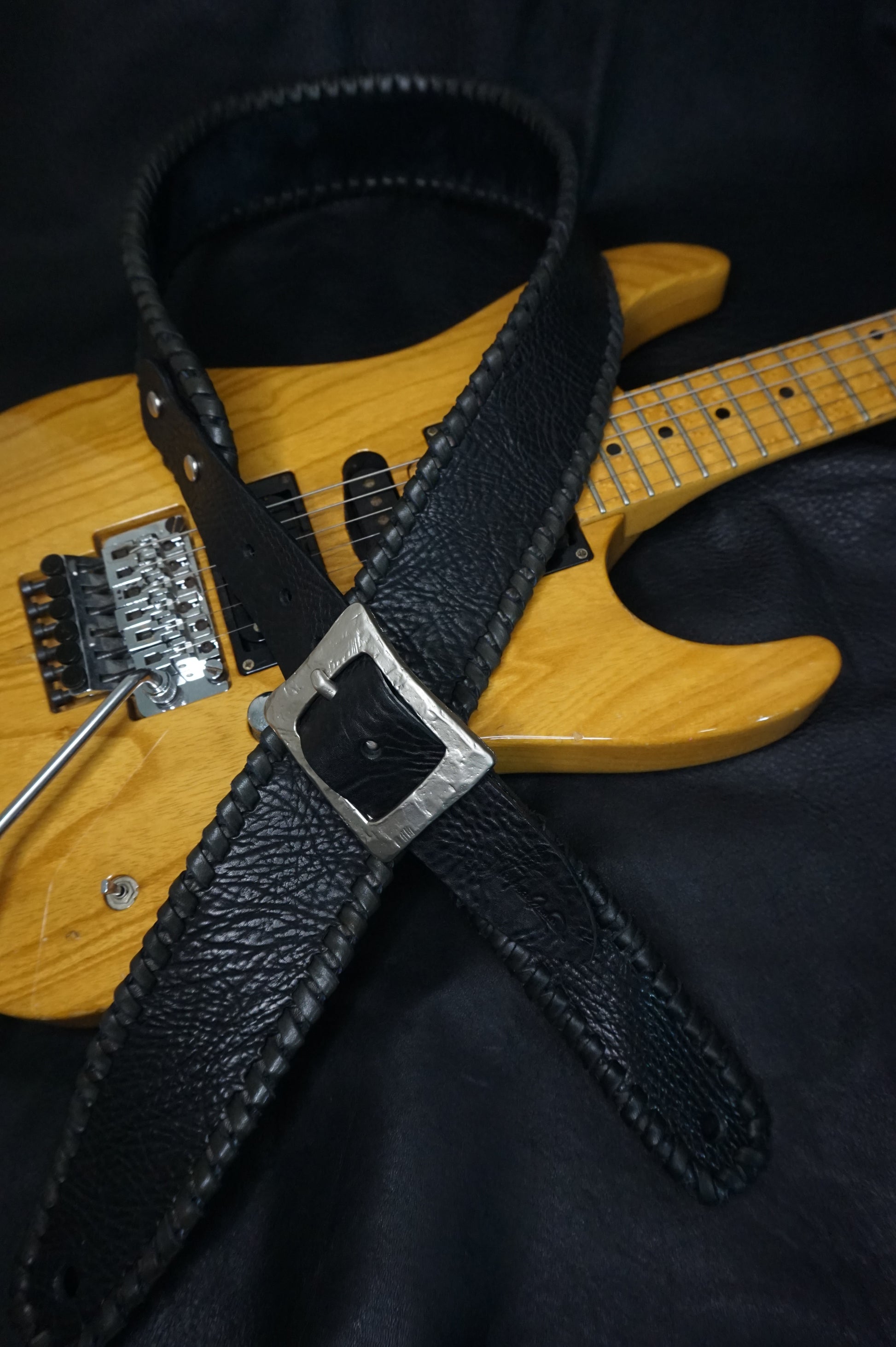 ASHIGARU "足軽" handmade leather guitar strap worn on electric guitar on stage, black shrink cowhide from Japan