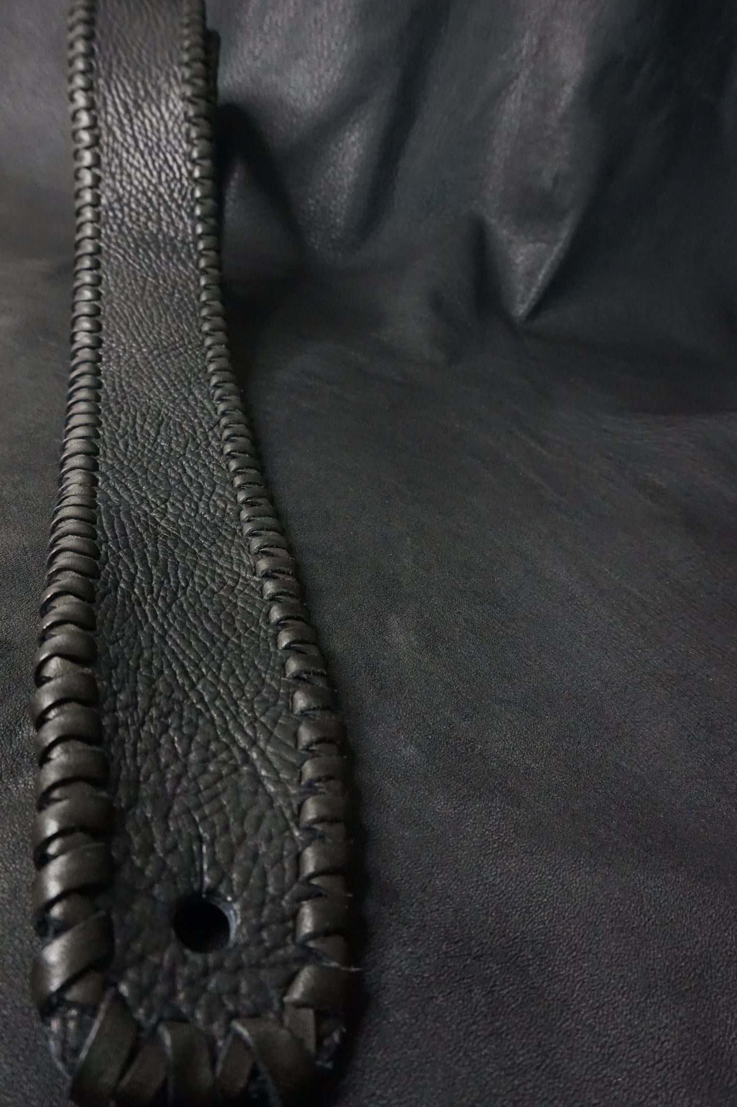 Close-up of black shrink leather texture on ASHIGARU TsukasaJames guitar strap