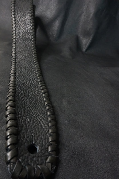 Close-up of black shrink leather texture on ASHIGARU TsukasaJames guitar strap