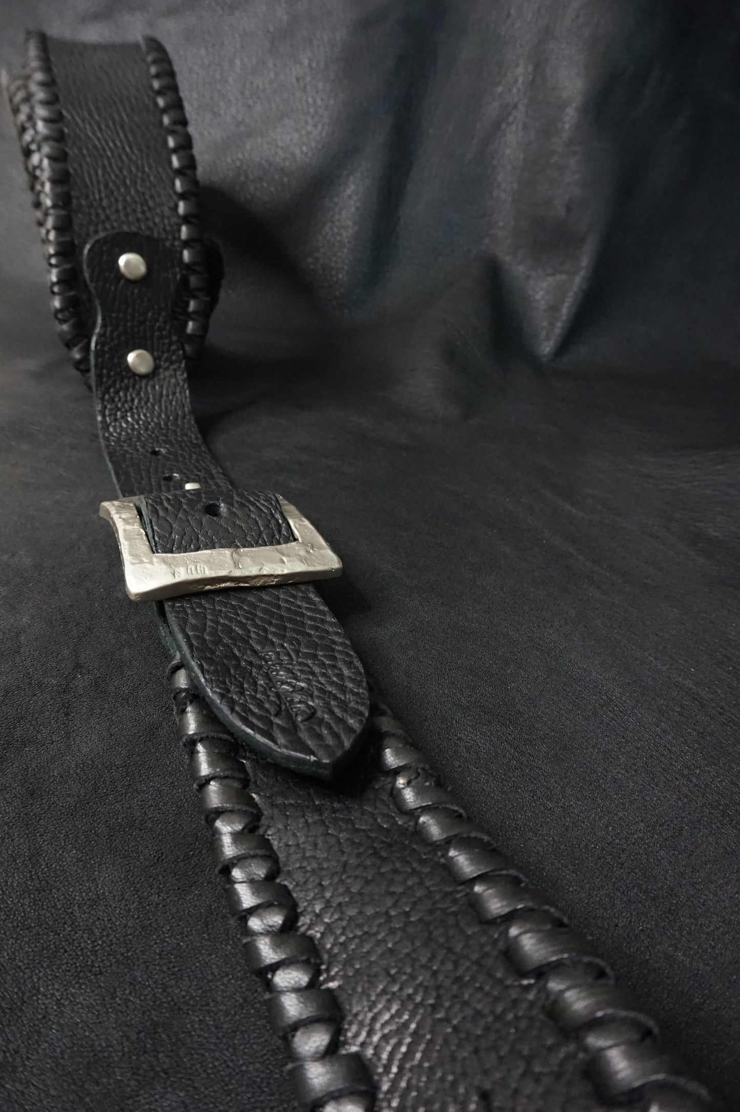 Whipstitching detail on ASHIGARU handmade black leather guitar strap from Japan