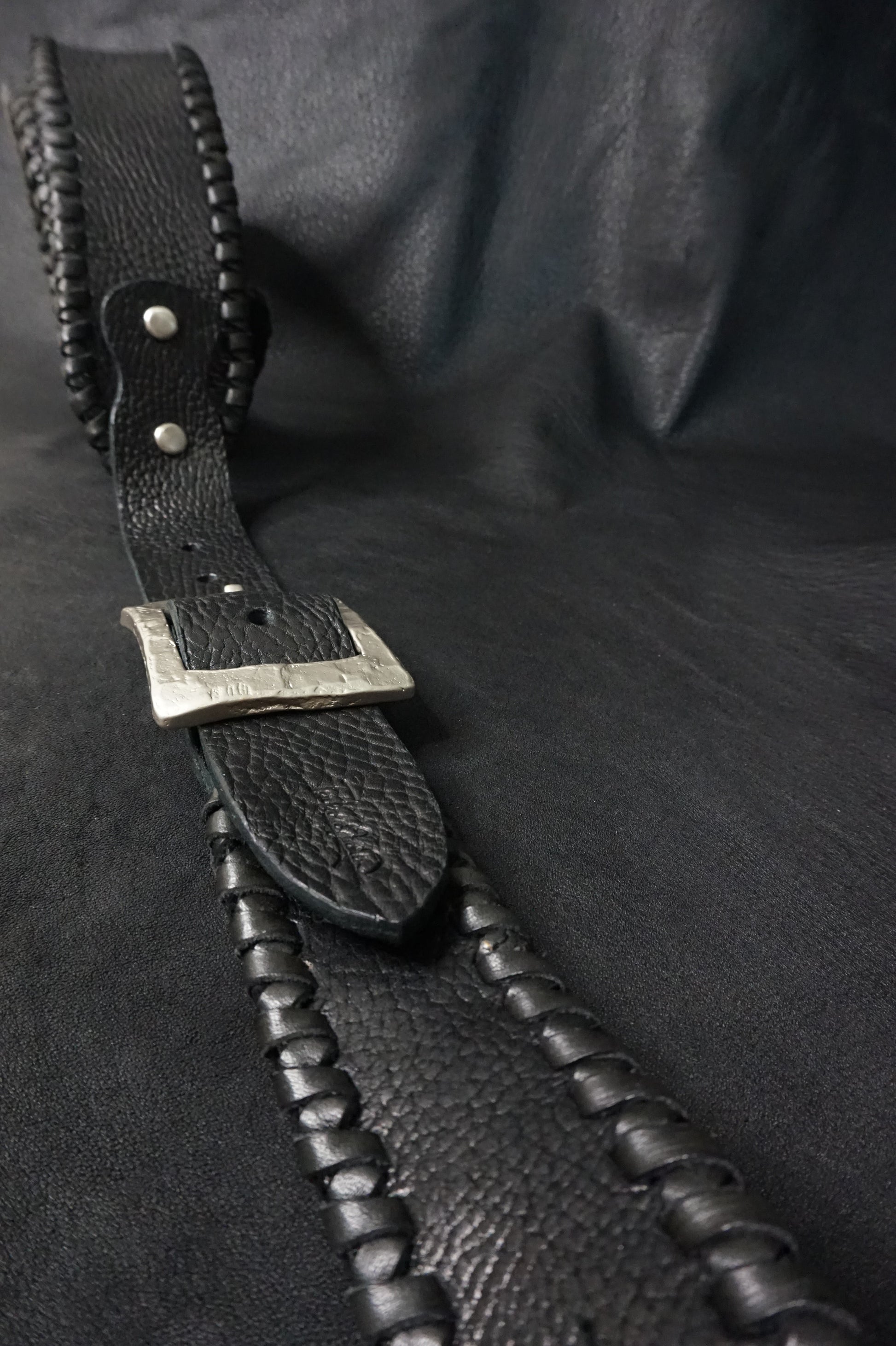 Whipstitching detail on ASHIGARU handmade black leather guitar strap from Japan